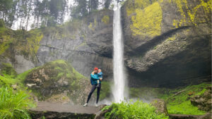 A mom holding her son near a waterfall