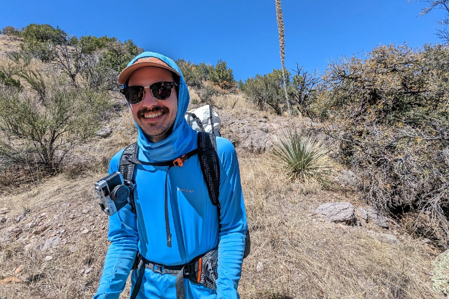 A smiling hiker wearing the Hyperlite Mountain Gear Unbound 40 on a desert trail