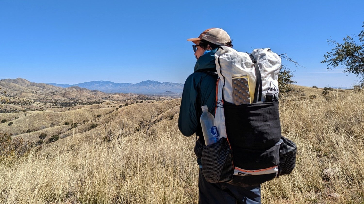 A hiker wearing the Hyperlite Mountain Gear Unbound 40 looking off at some distant mountains