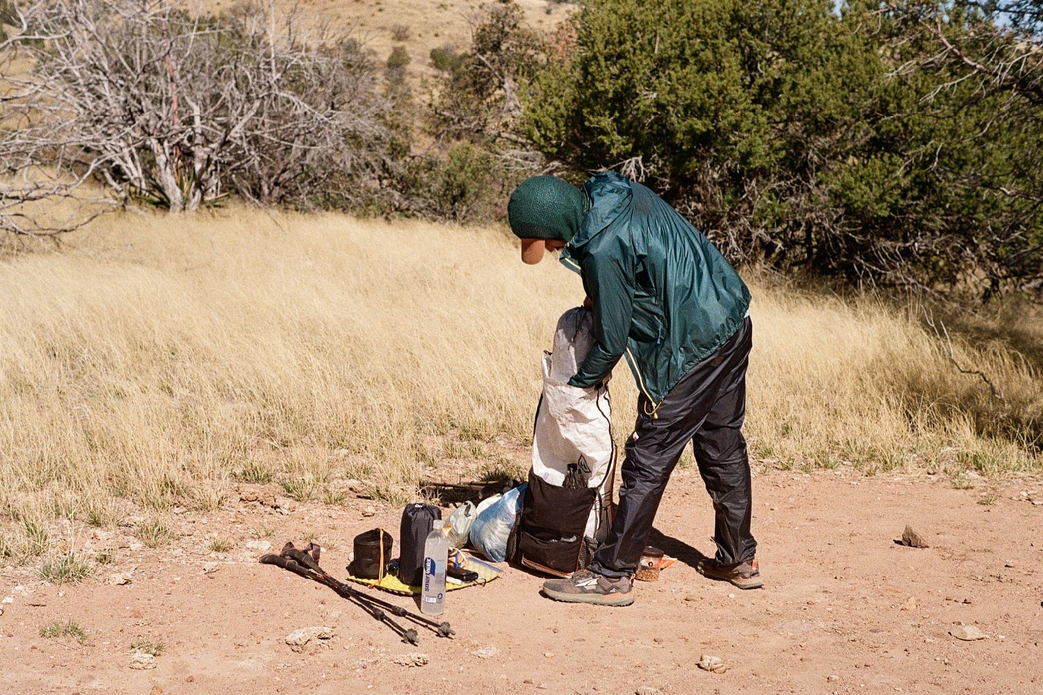 A hiker packing their into a Hyperlite Mountain Gear Unbound 40