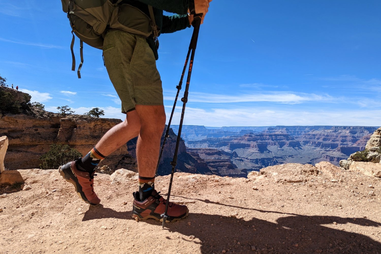 A torso down view of a hiker hiking on a trail in the Grand Canyon