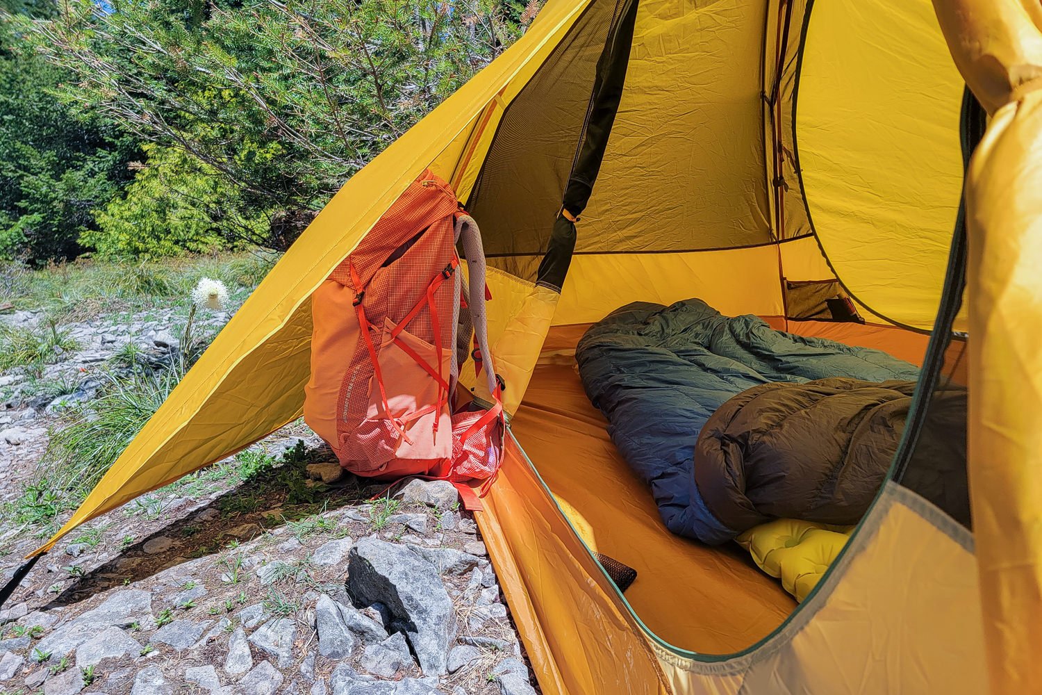 A few of the vestibules of the Trailmade 2 tent with a backpack under the rain fly