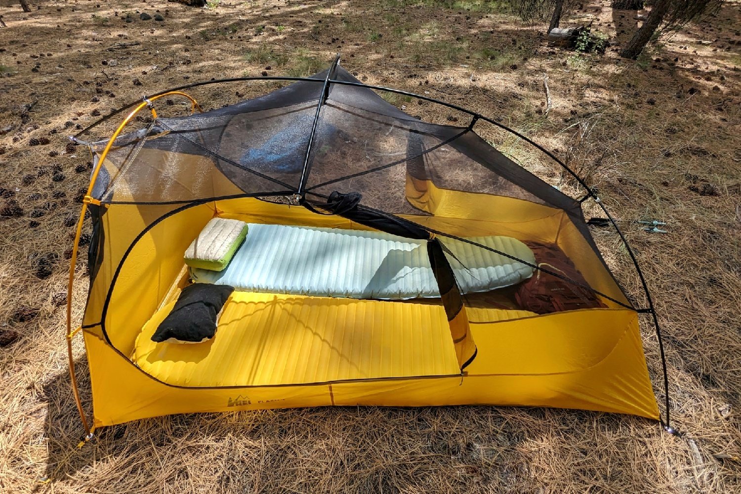 The Therm-a-Rest NeoAir Xlite NXT and Therm-a-Rest NeoAir Xtherm NXT laid next to each other in a tent - the view into the tent is from the top down