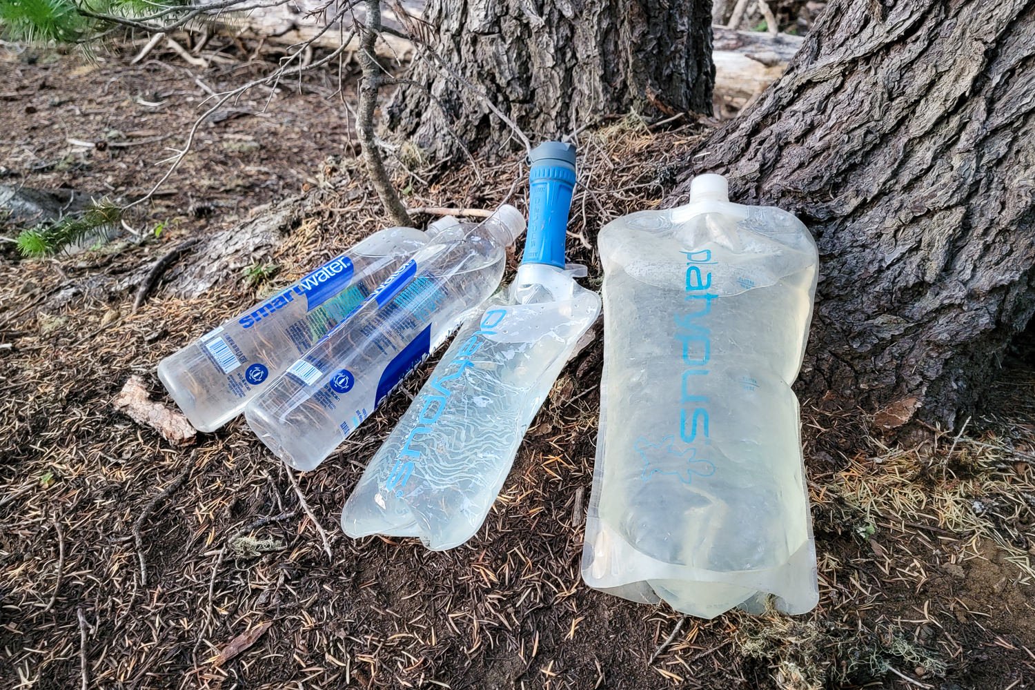 The Platypus QuickDraw leaning against a tree with smartwater and Platy Bottles