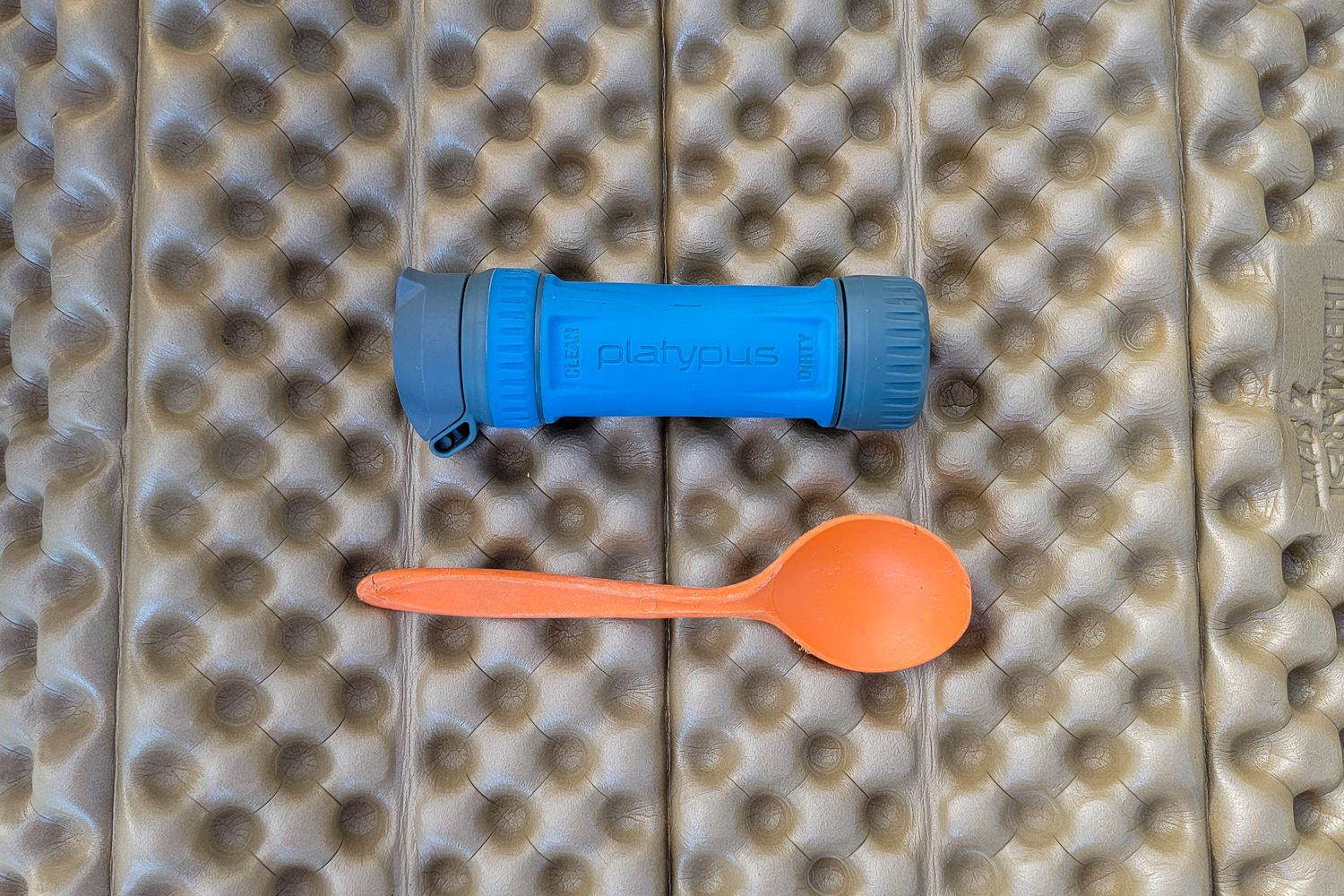 Top-down view of the Platypus QuickDraw next to a backpacking spoon for size