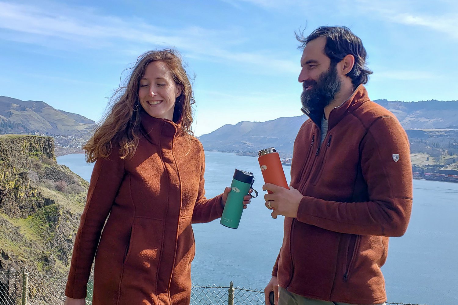 Two people standing in front of a river gorge view holding GSI Microlite bottles