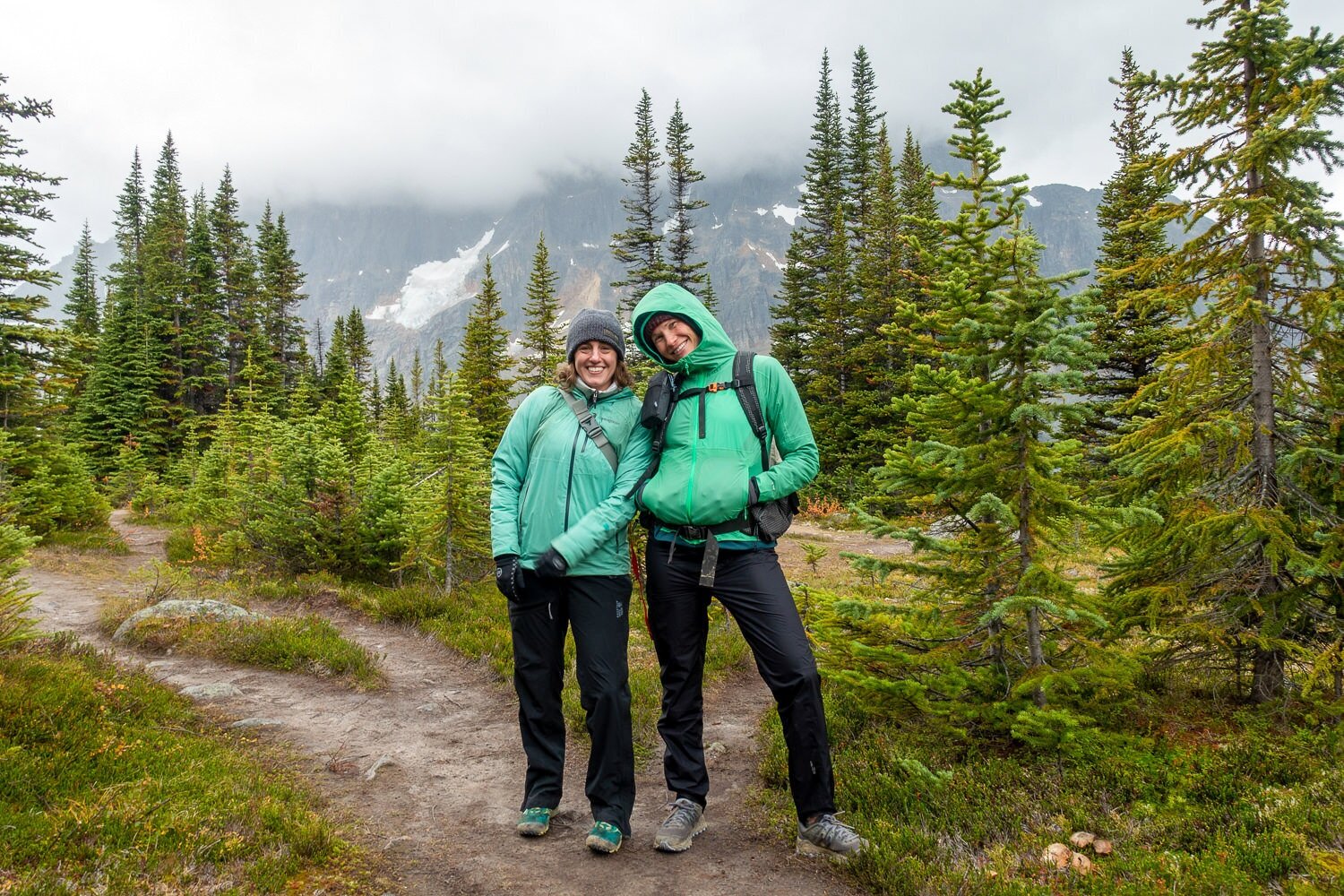 Two female backpackers in rain gear including the REI XeroDry Pants