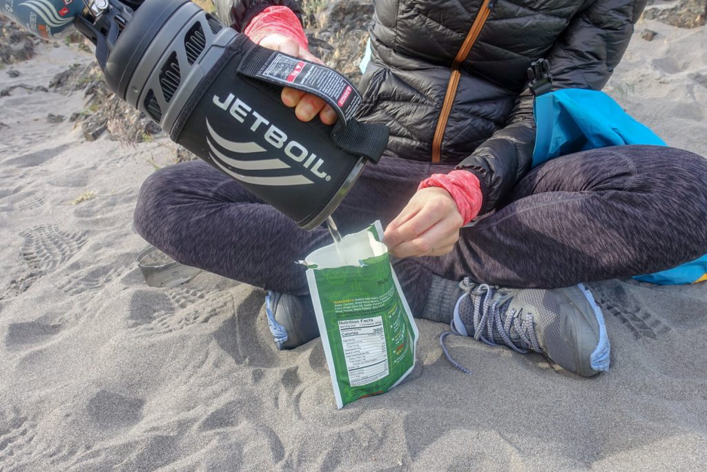 person pours water into meal pouch