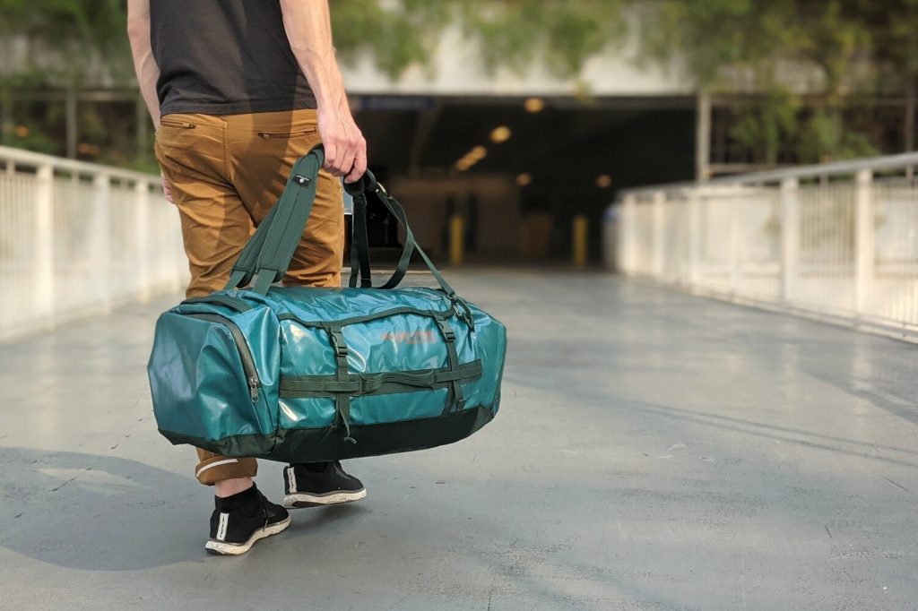 A man walking towards the airport with the Eagle Creek Cargo Hauler 60 duffel bag