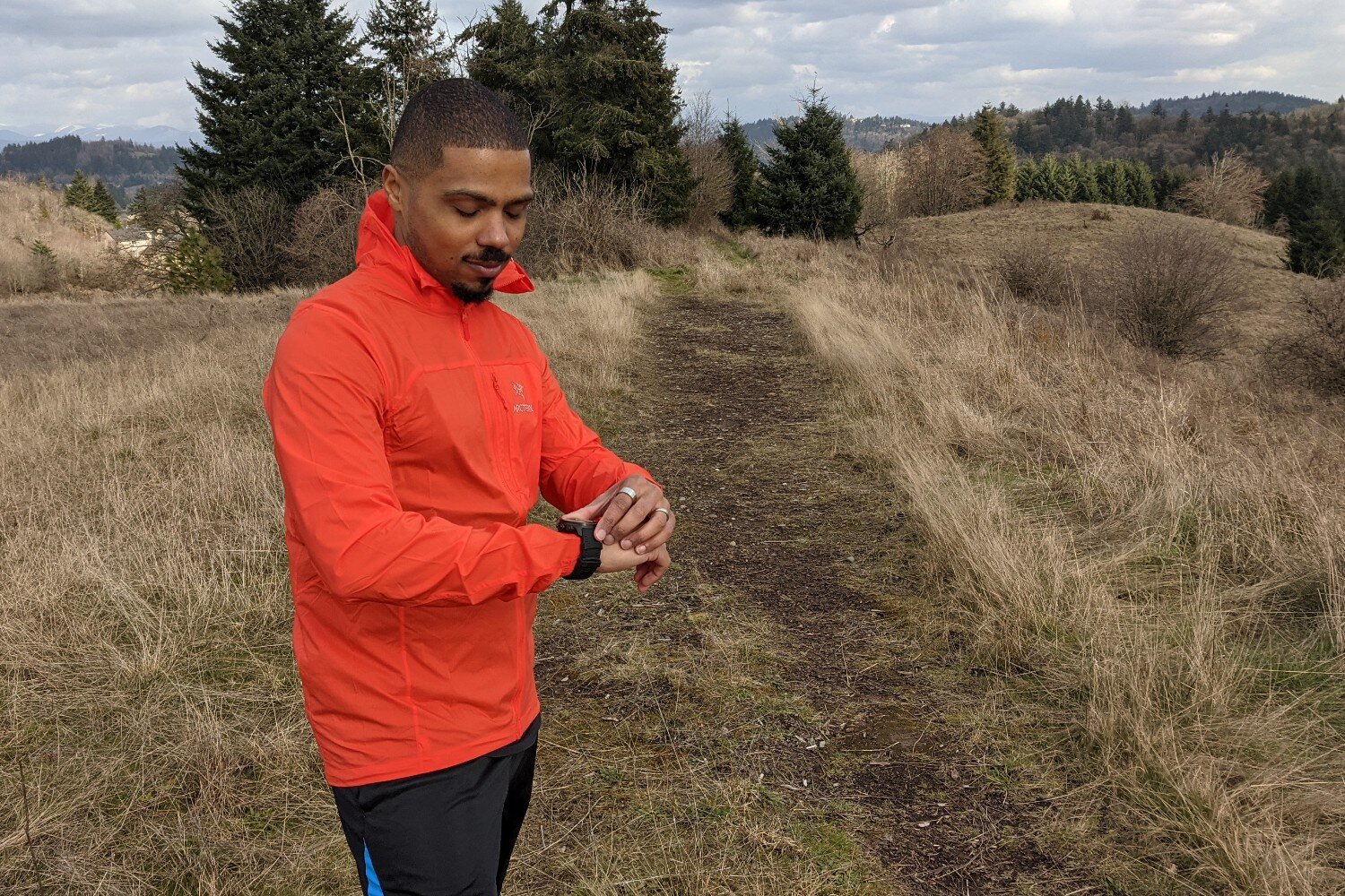 A runner looking at a GPS watch on his wrist