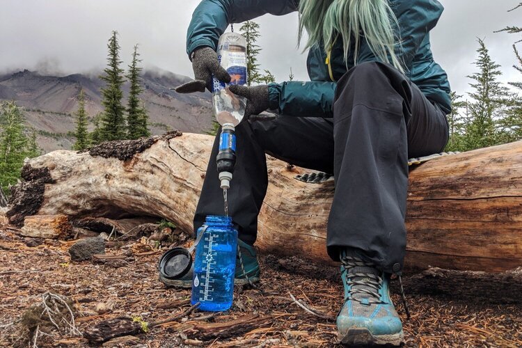 Closeup of a hiker filter water with the Sawyer Squeeze