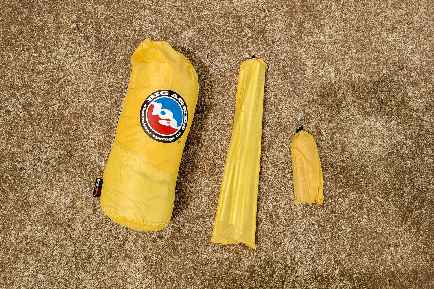 The components of the Big Agnes Tiger Wall UL2 broken down into stuff sacks: tent body and fly, tent poles, and tent stakes