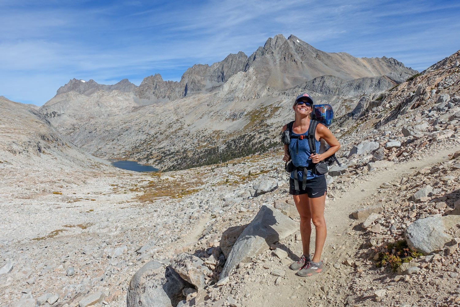 A female backpacker wearing the Nike Dri-FIT Tempo shorts on a mountain pass along the John Muir Trail