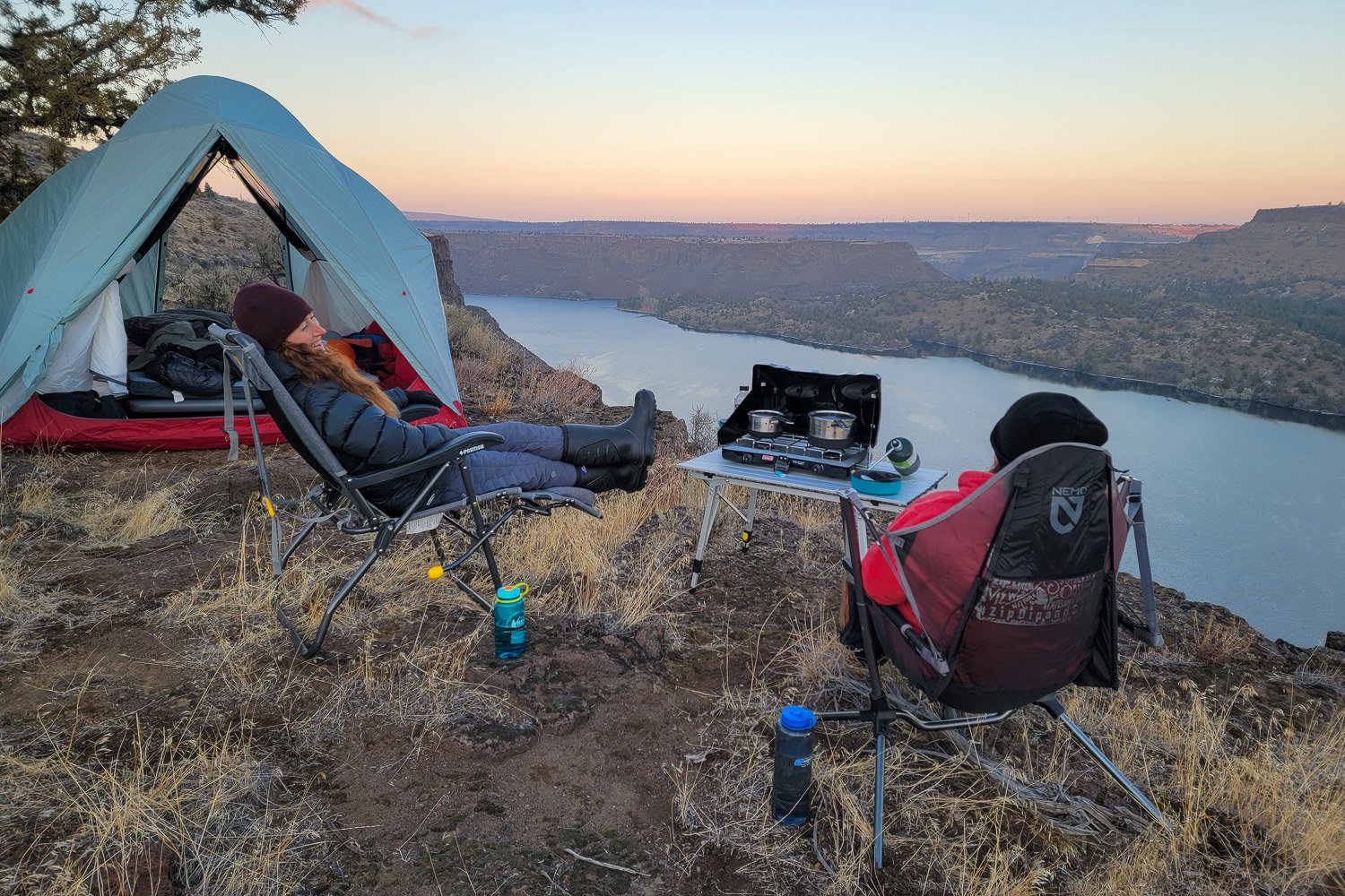 Two campers using the Portal Wide-N-Compact Camping Table on a mesa overlooking the Metolius River