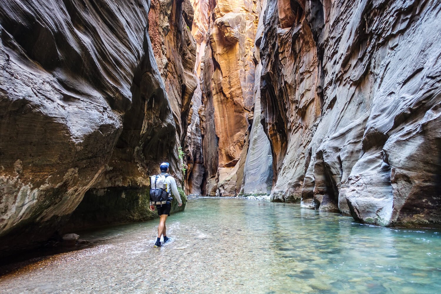 A hiker wearing an Hyperlite Mountain Gear Ultralight Backpack in a slot canyon in Utah
