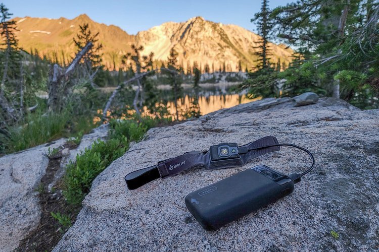 Iniu 20000 sitting on a rock charging a headlamp