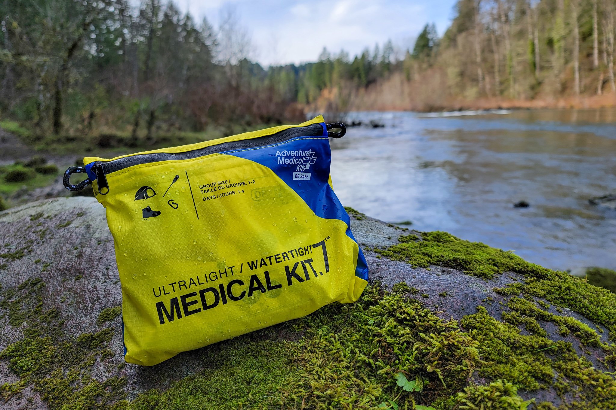 Closeup of the AMK Ultralight/Watertight .7 First Aid Kit in front of a Pacific Northwest River