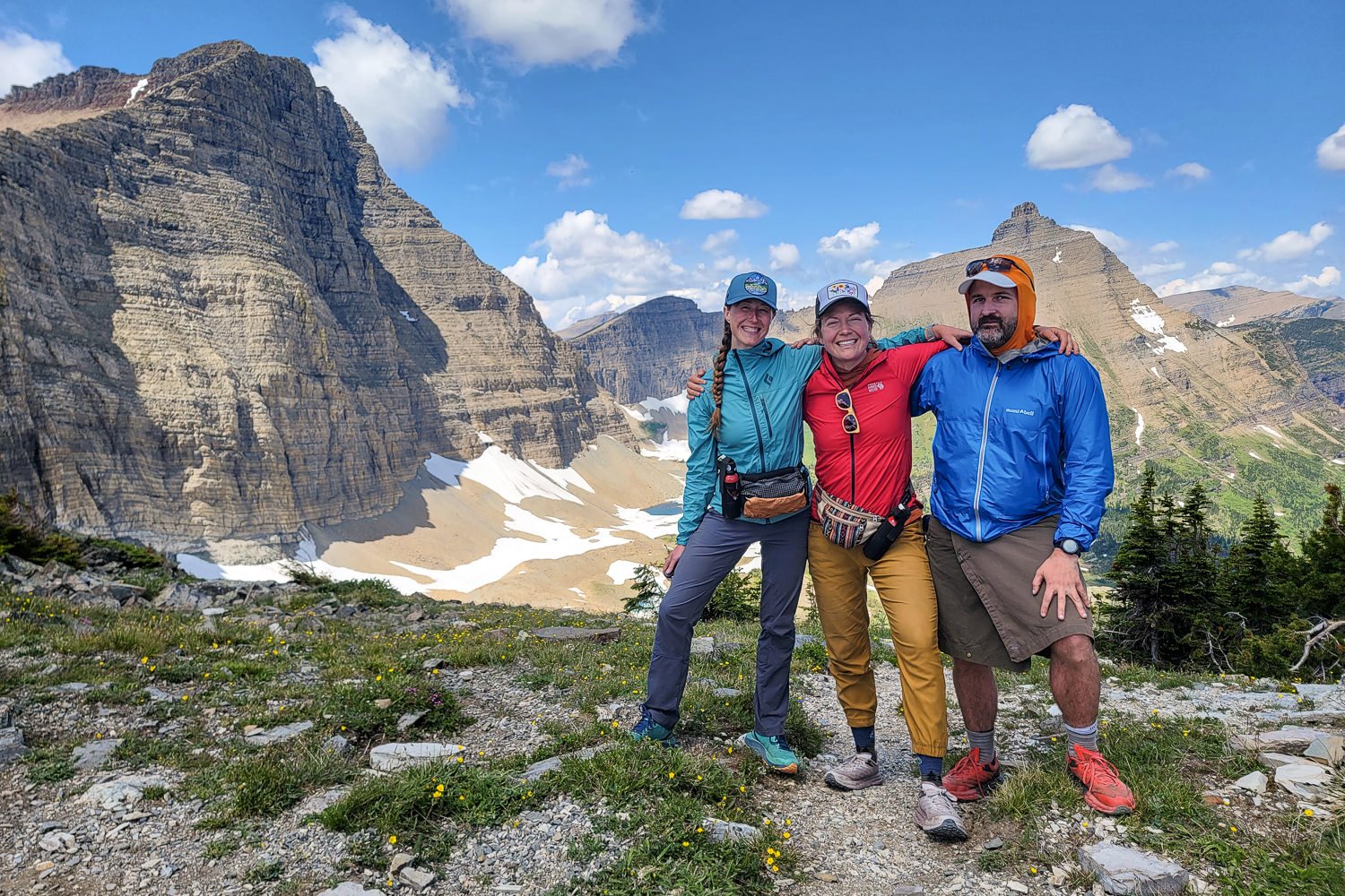 Backpackers posing at the summit of a pass in Glacier National Park