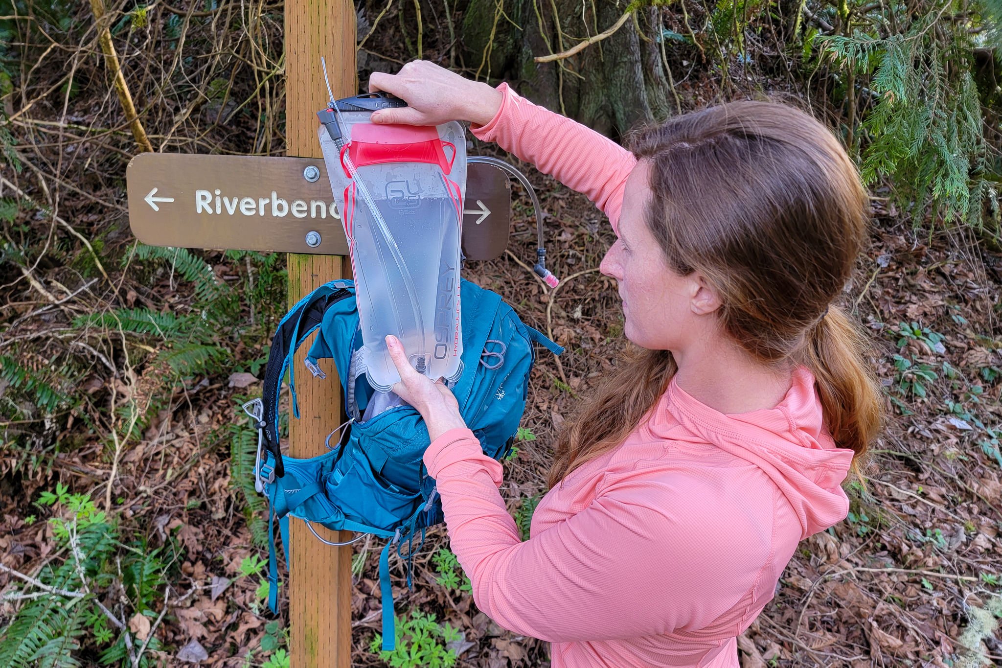 A hiker checking the level in her Osprey Hydraulics LT hydration bladder
