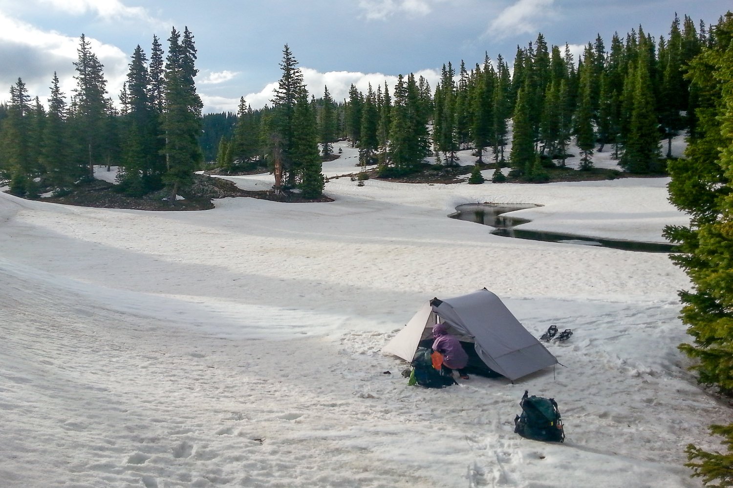 Distant shot of the Lunar Duo pitched in a snowy meadow next to a creek