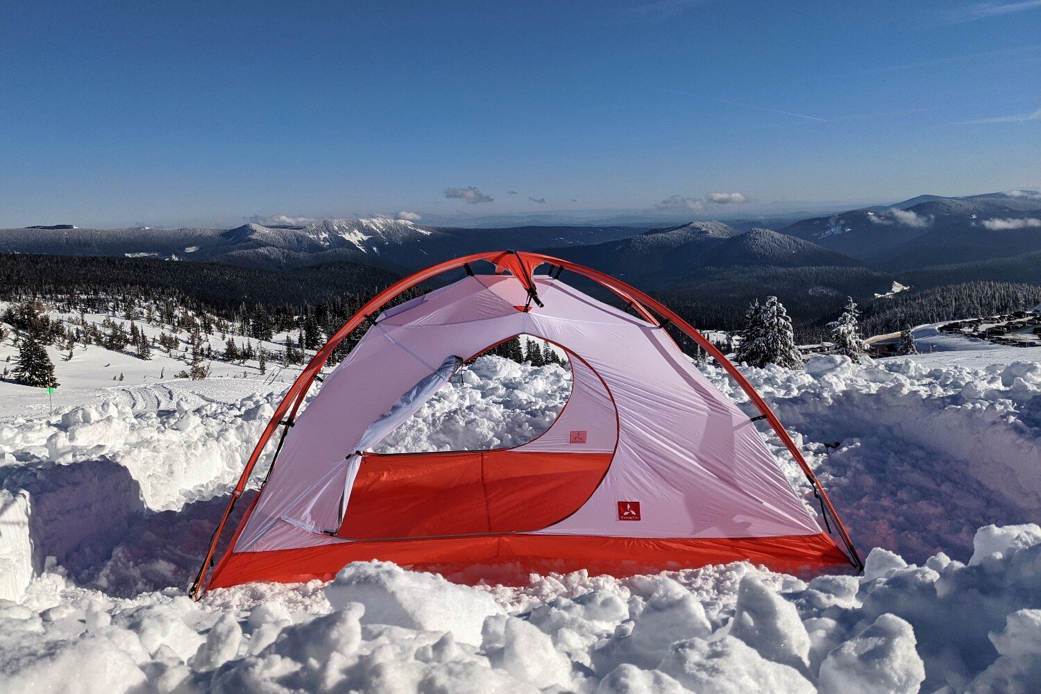 The Slingfin Crossbow 4 season tent set up with both of its doors open in front of a snowy valley scene