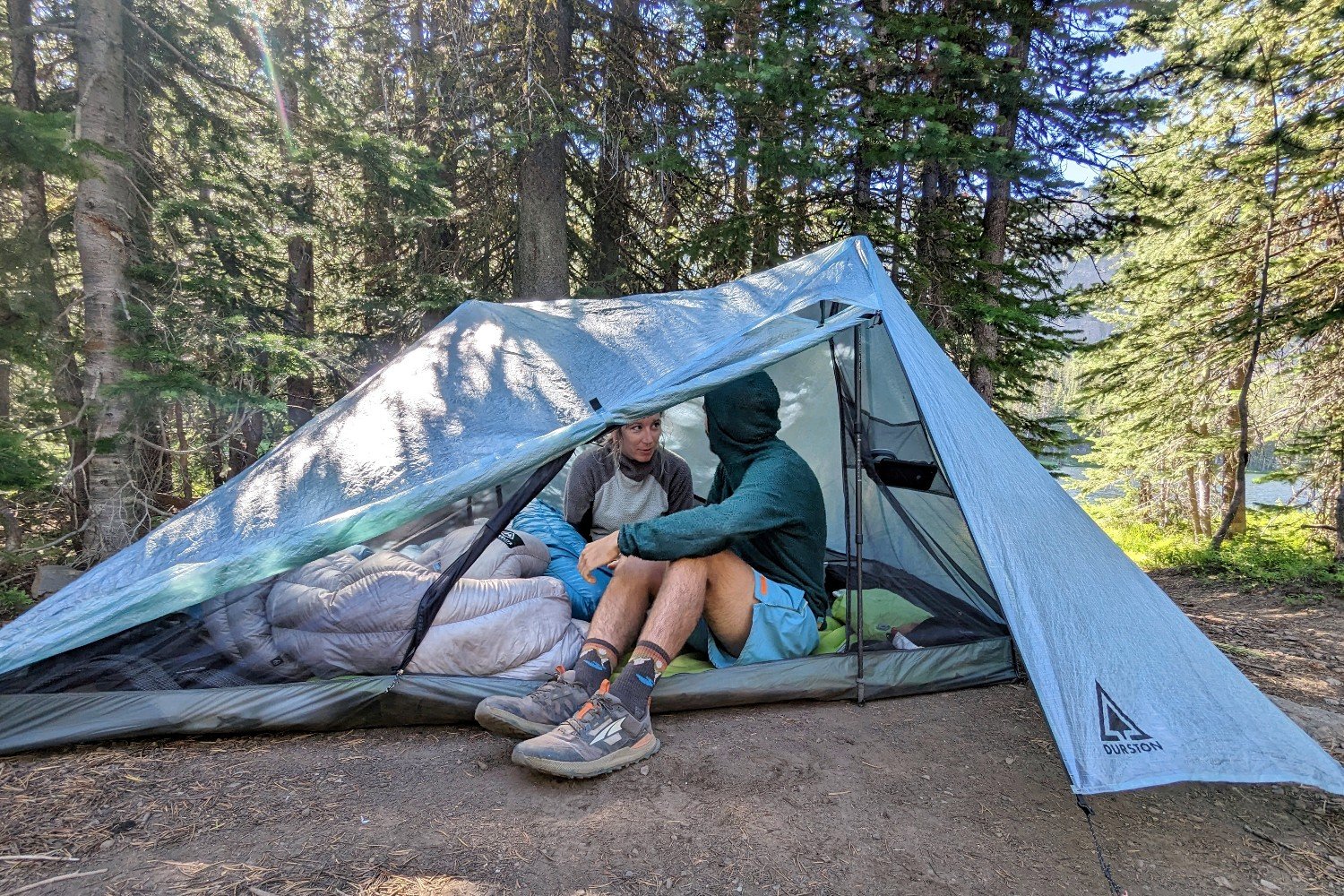 Two hikers sitting inside the Durston X-Mid 2 Pro tent with the front door and vestibule open