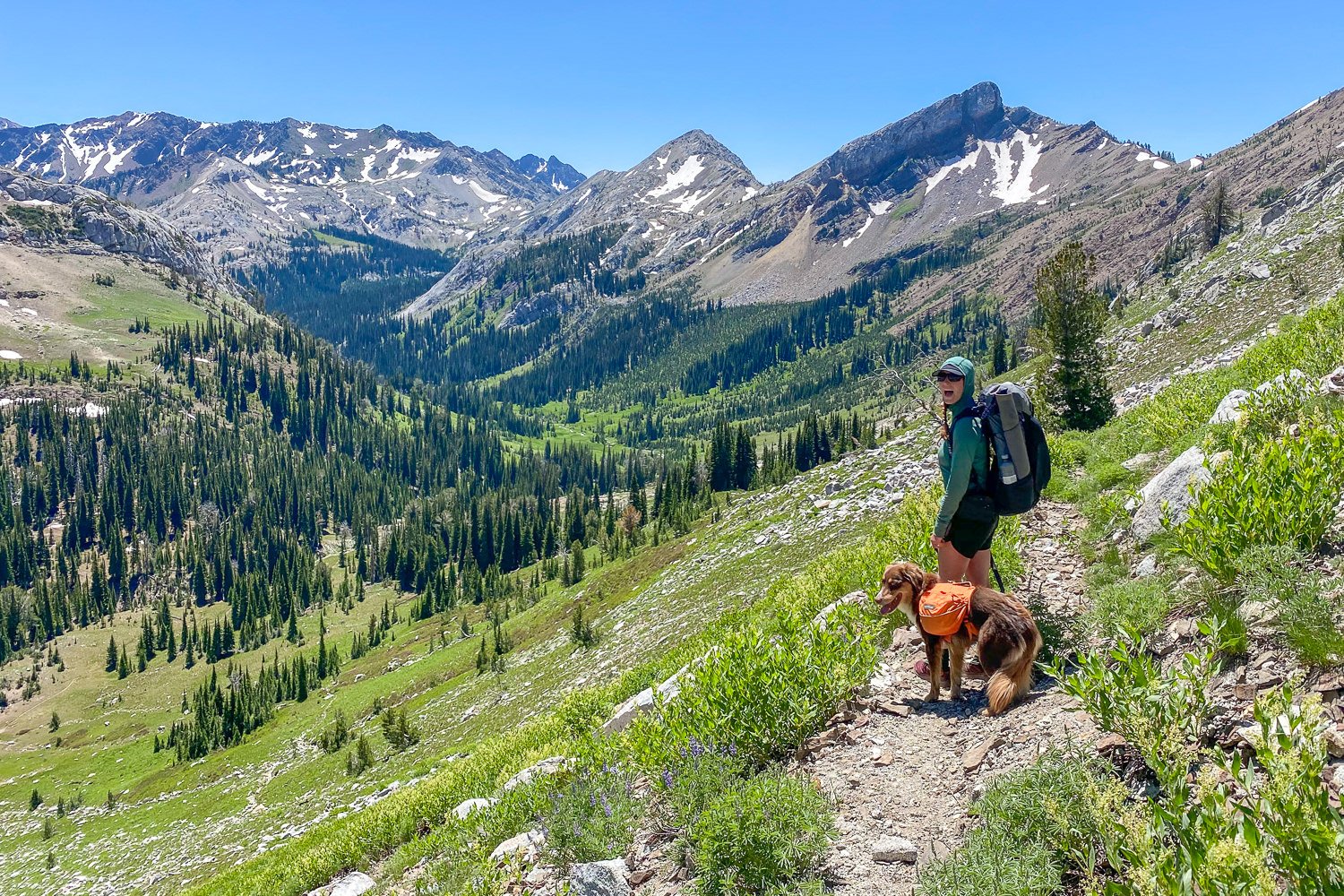 A backpacker wearing a sun shirt and running shorts on a trail in the mountains for the Eagle Cap Wilderness