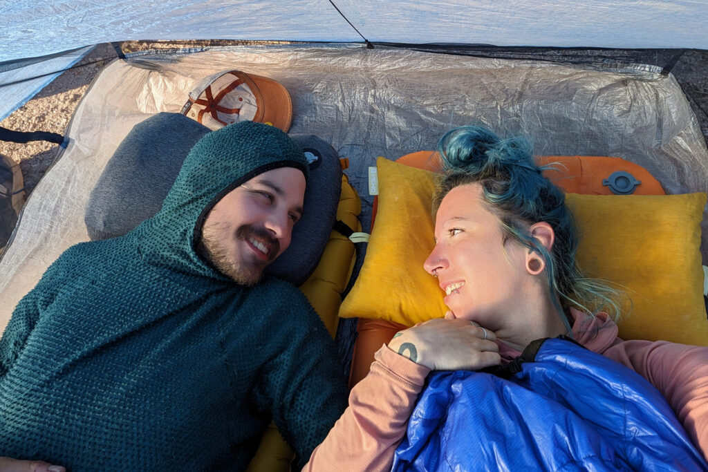 Two hikers laying down inside the Zpacks Duplex Zip tent looking at each other with smiles on their faces