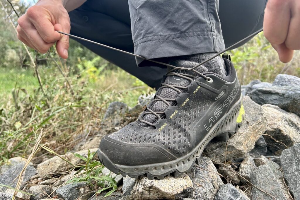 Closeup of a hiker tying the laces of the La Sportiva Spire GTX hiking shoes