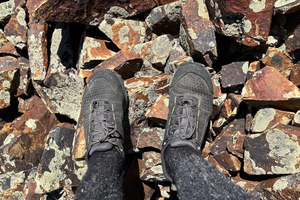 A hiker testing the La Sportiva Spires on loose scree