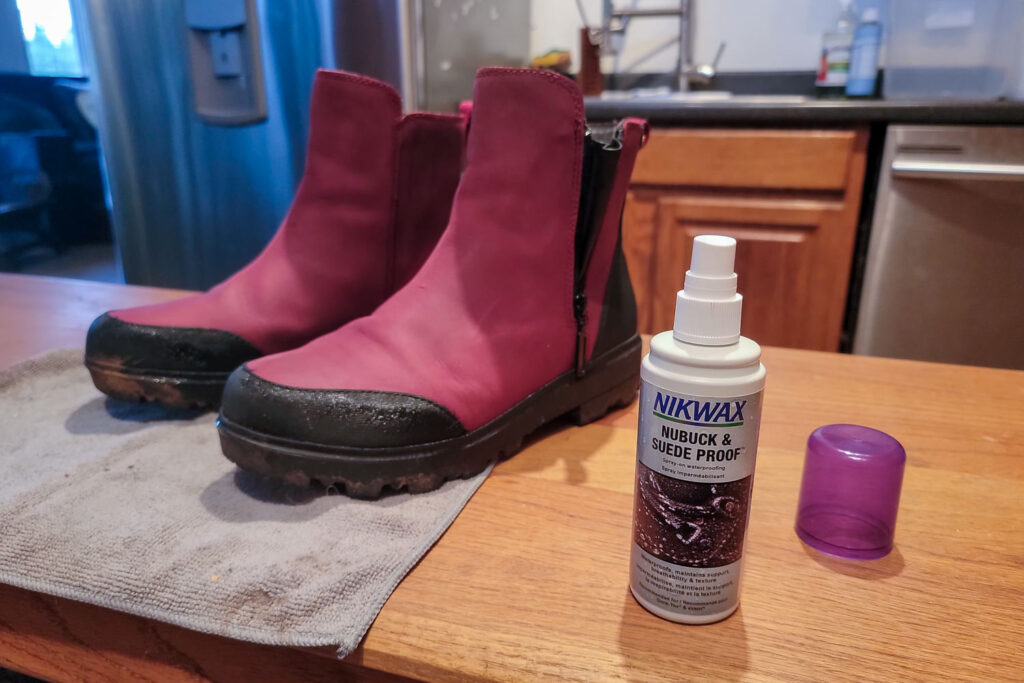 Nikwax Nubuck & Suede Proof next to a pair of Bogs ankle boots in a kitchen
