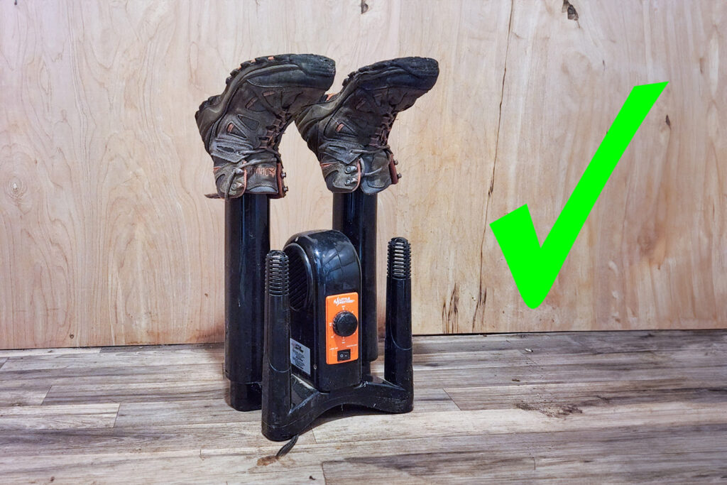 A pair of hiking boots on a boot drier with a green checkmark