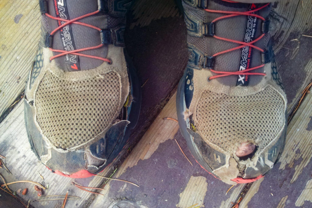 Closeup of the toes of a pair of very well worn hiking shoes