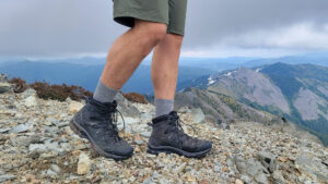 Knee-down view of a hiker walking a ridge in the Cascade Mountains in the Men's Salomon Quest 4 GTX hiking boots