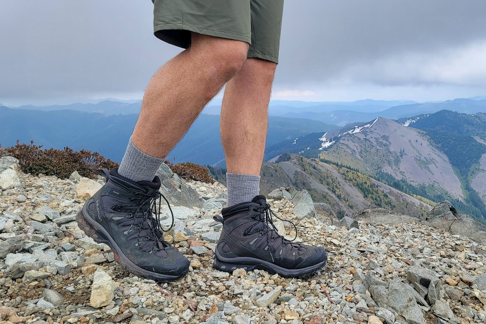 Knee-down view of a hiker walking a ridge in the Cascade Mountains in the Men's Salomon Quest 4 GTX hiking boots