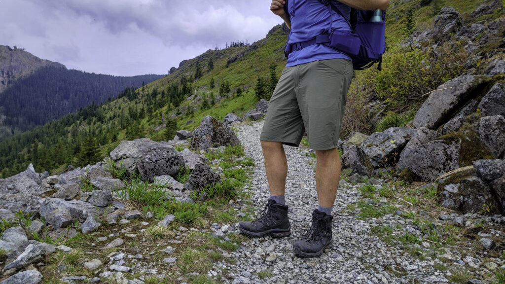 Waist-down view of a hiker standing on a rocky trail in the men's Patagonia Quandary hiking shorts