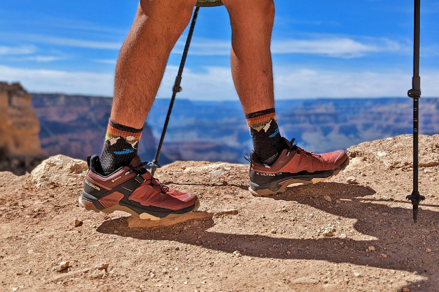 Closeup of a hiker's feet in the Darn Tough Light Hiker Micro Crew socks and Salomon X Ultra shoes on the rim of the Grand Canyon