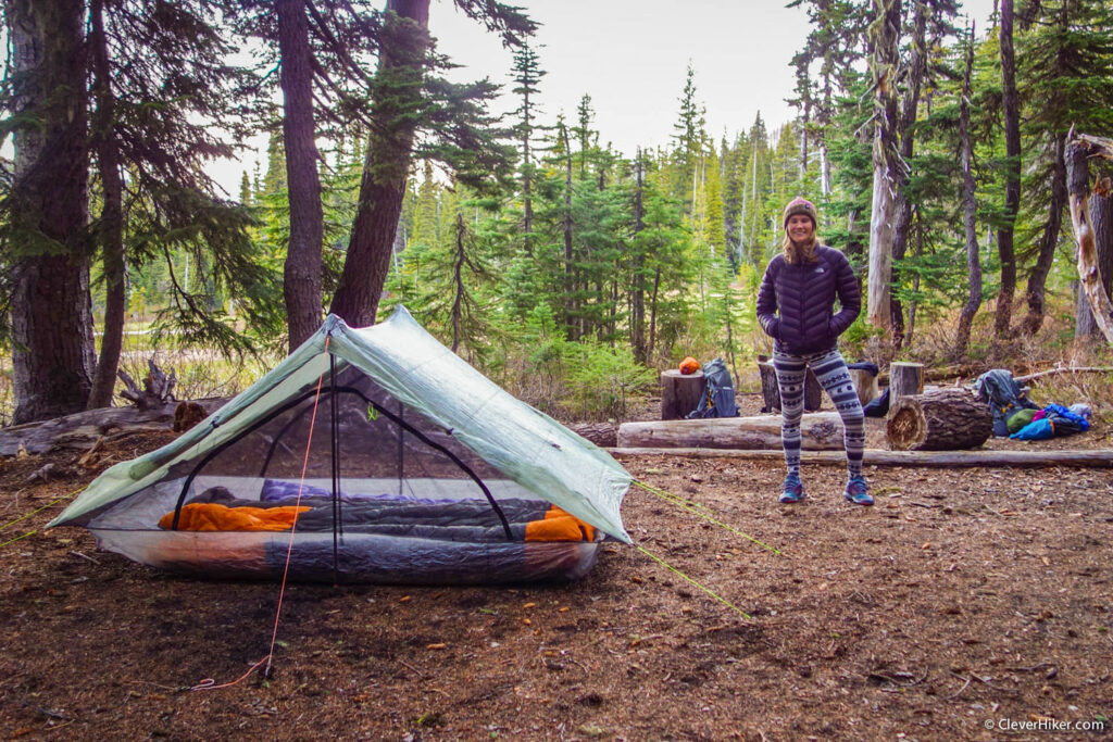 A backpacker standing next to the Zpacks Duplex tent in a campsite near Elk Meadows