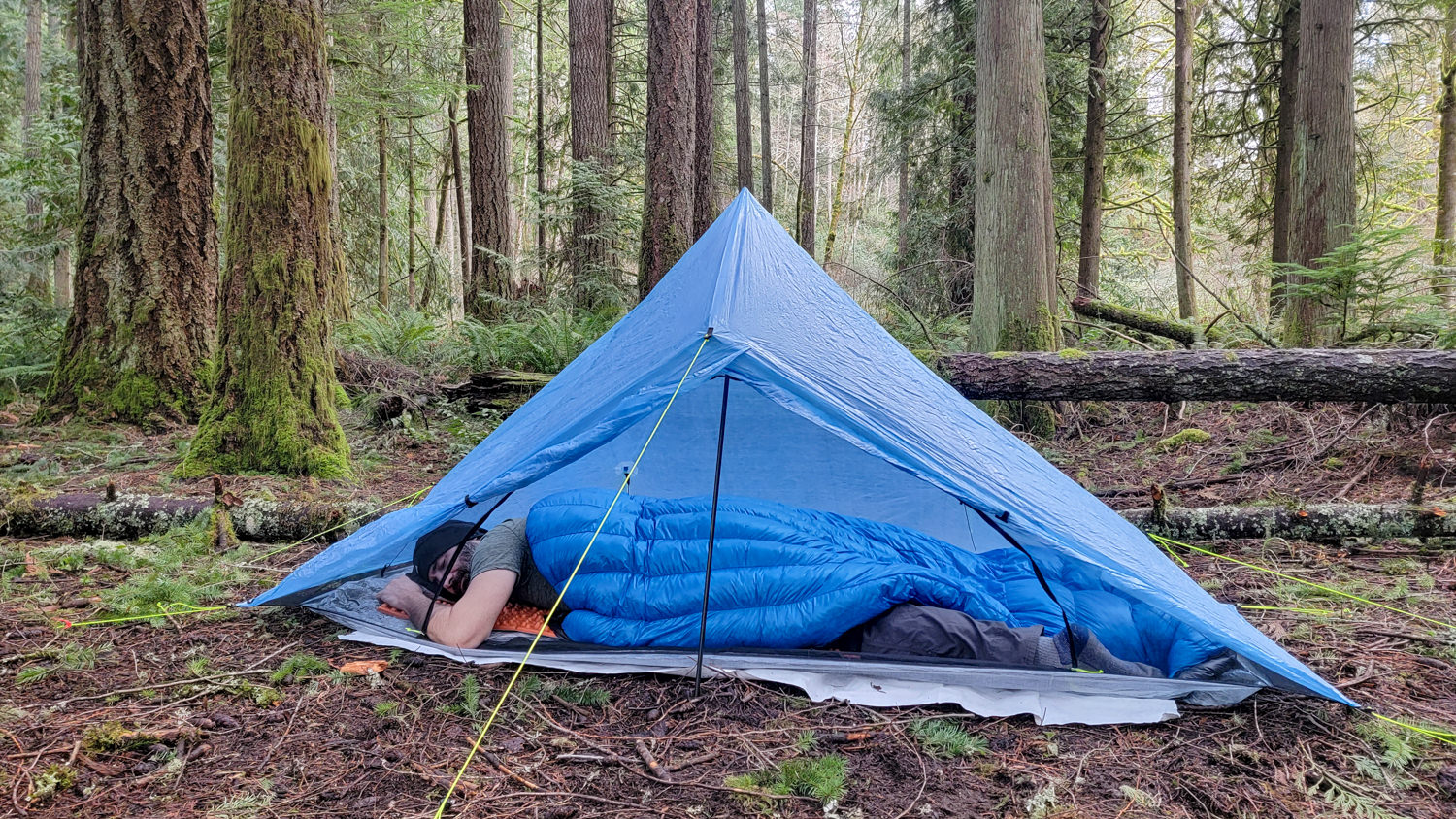 A backpacker sleeping in the Zpacks Plex Solo tent with the Zpacks Mummy Bag open for ventilation
