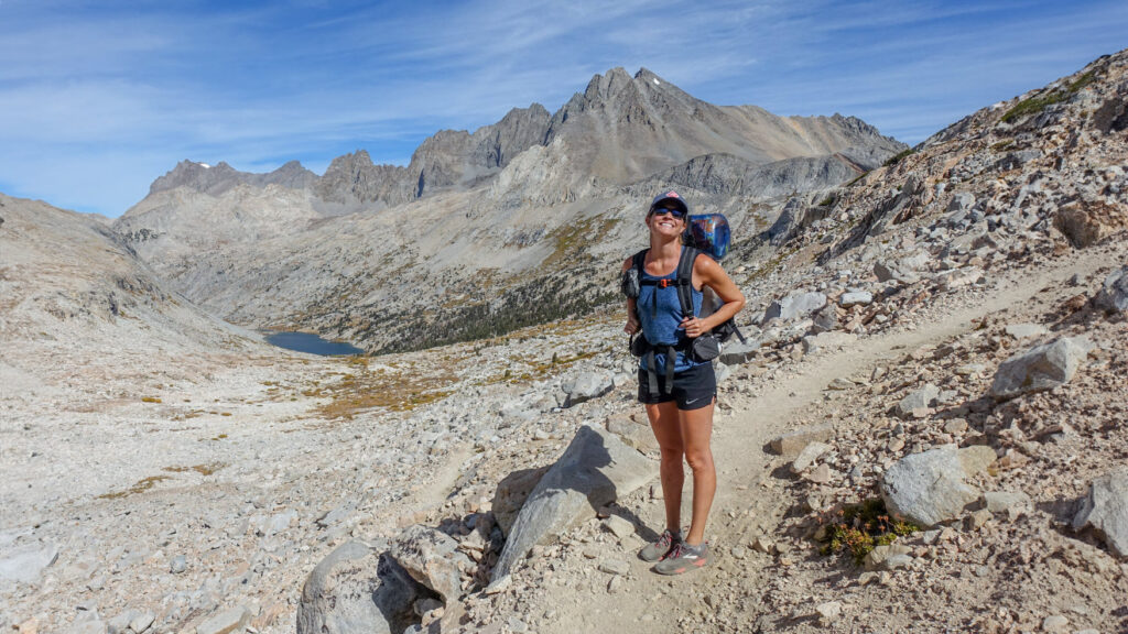 A female backpacker wearing the Nike Dri-FIT Tempo shorts on a mountain pass along the John Muir Trail