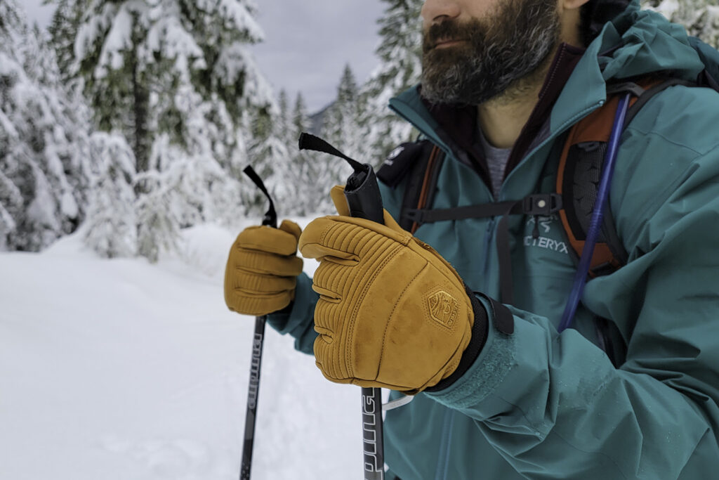 Closeup of a bearded man wearing the Hestra Fall Line gloves on a snowshoeing trail