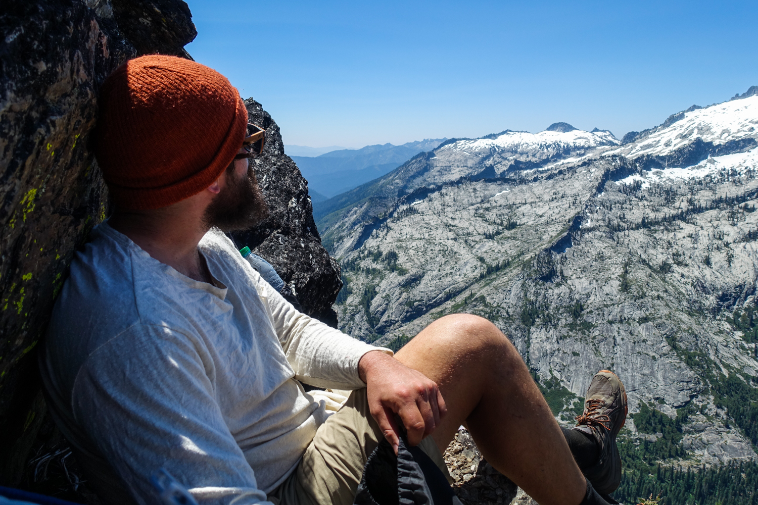 backpacker in the trinity alps resting on a rock overlooking the mountains