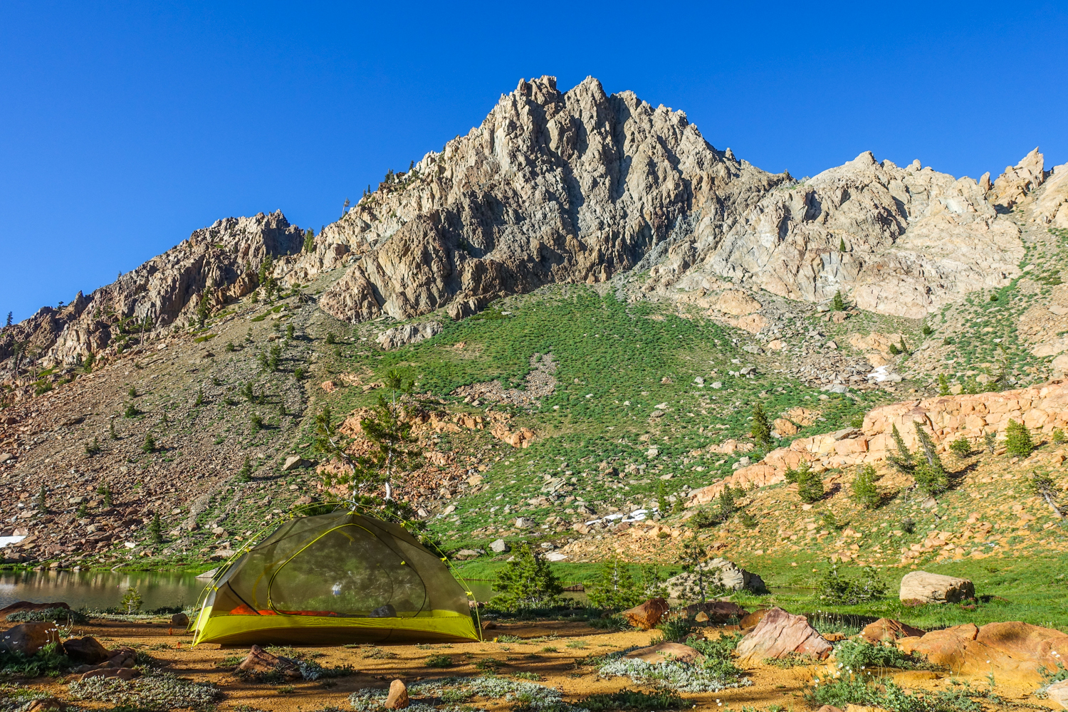 tent pitched under a rocky mountain in the trinity alps
