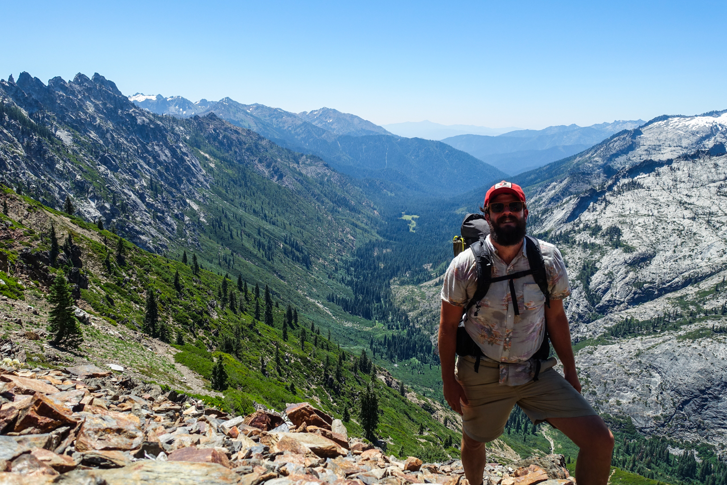 backpacker in the trinity alps posing above a large drainage.