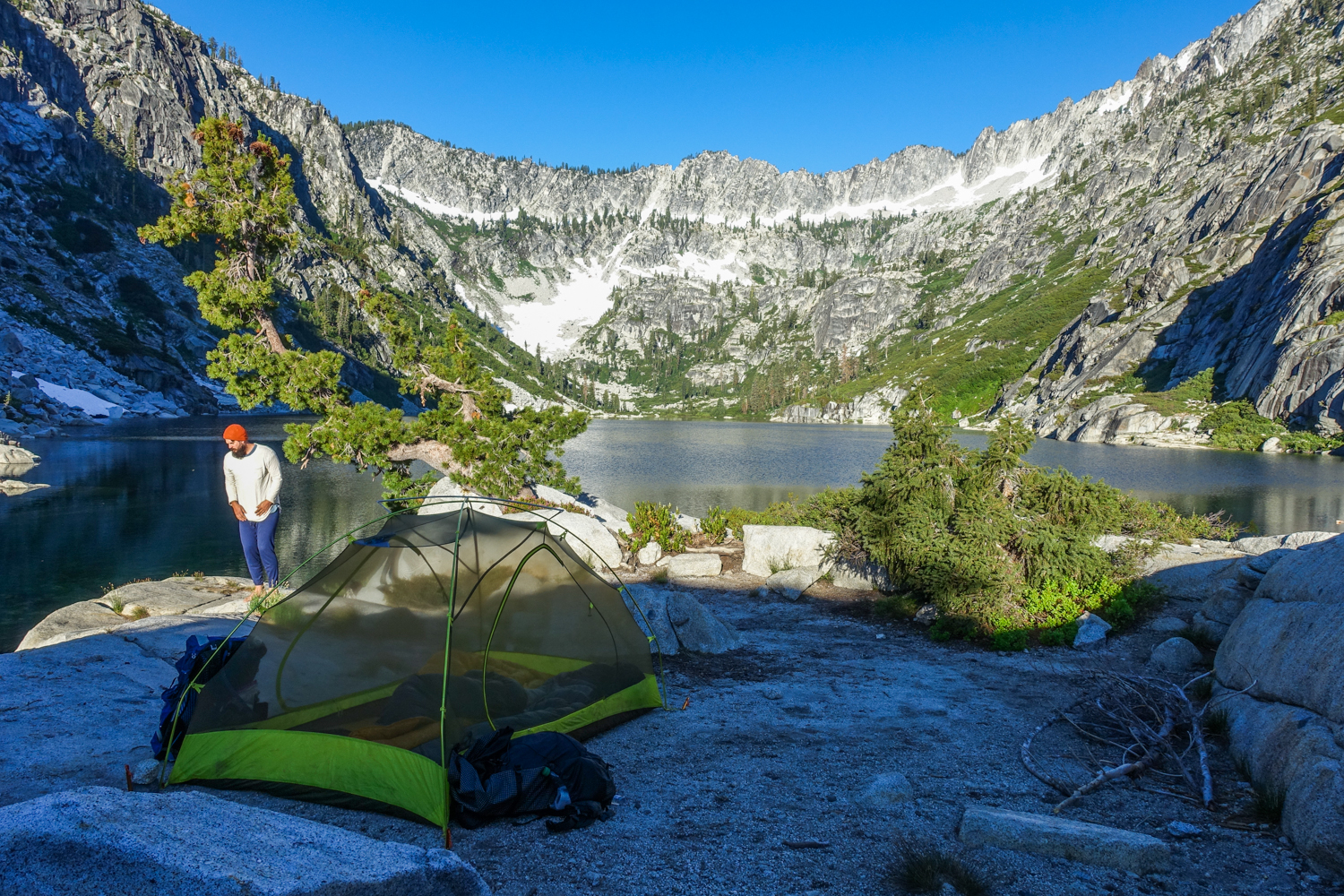 campsite at the rock slab edge of a glacial lake in a basin in the trinity alps