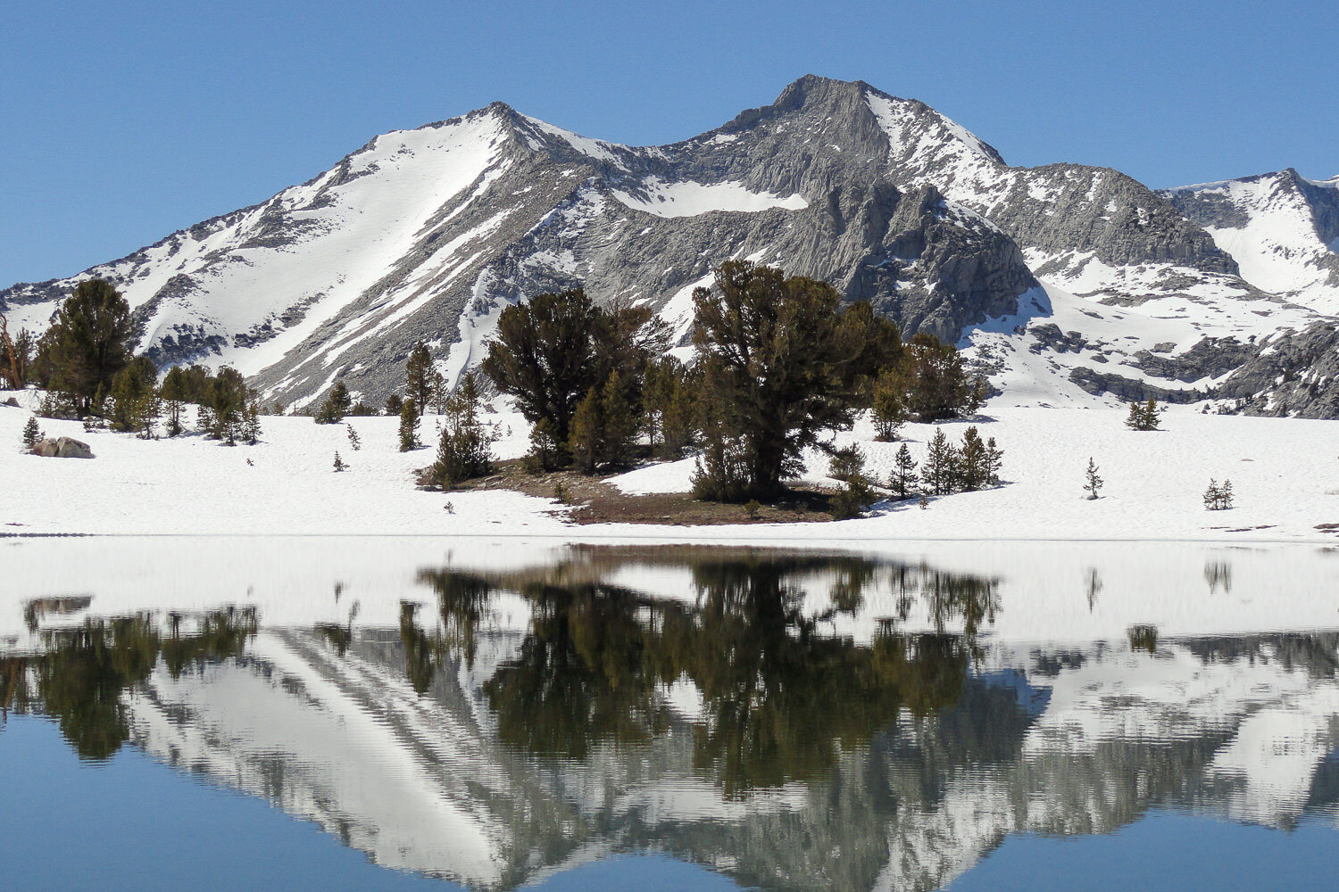 snowy mountain reflected in an alpine lake
