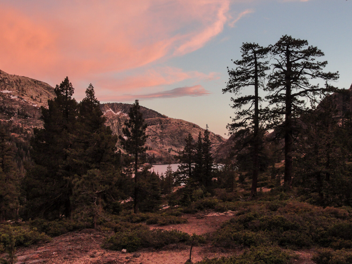 mountain and lake sunset with evergreens silhouetted