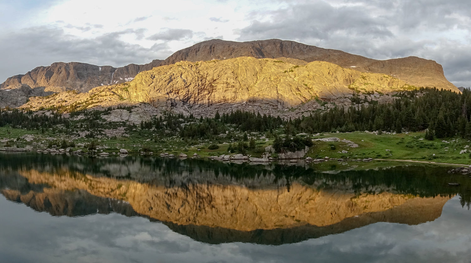 a wide mountain in yellow sunset glow