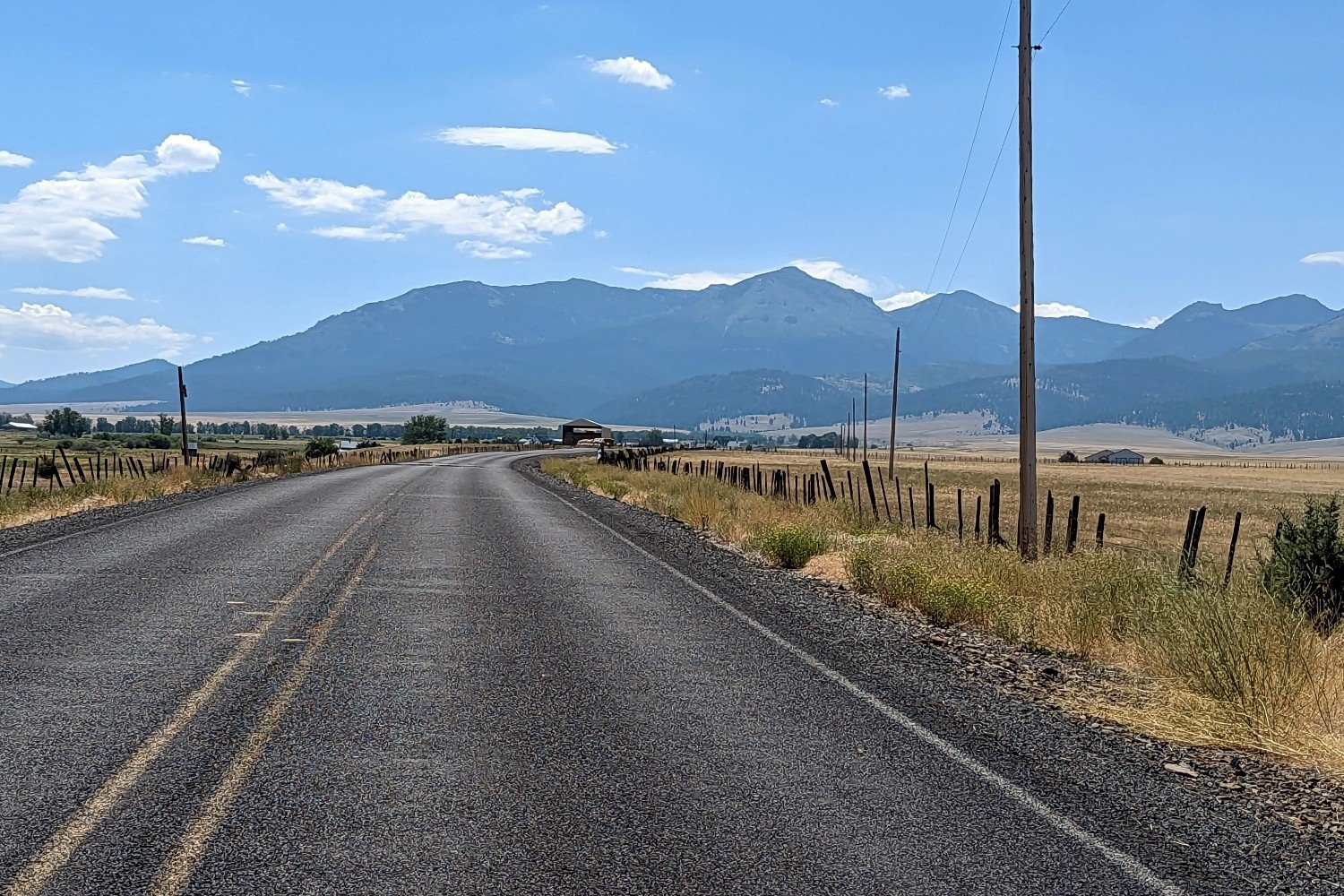 paved road leading to the rising strawberry mountains in eastern oregon