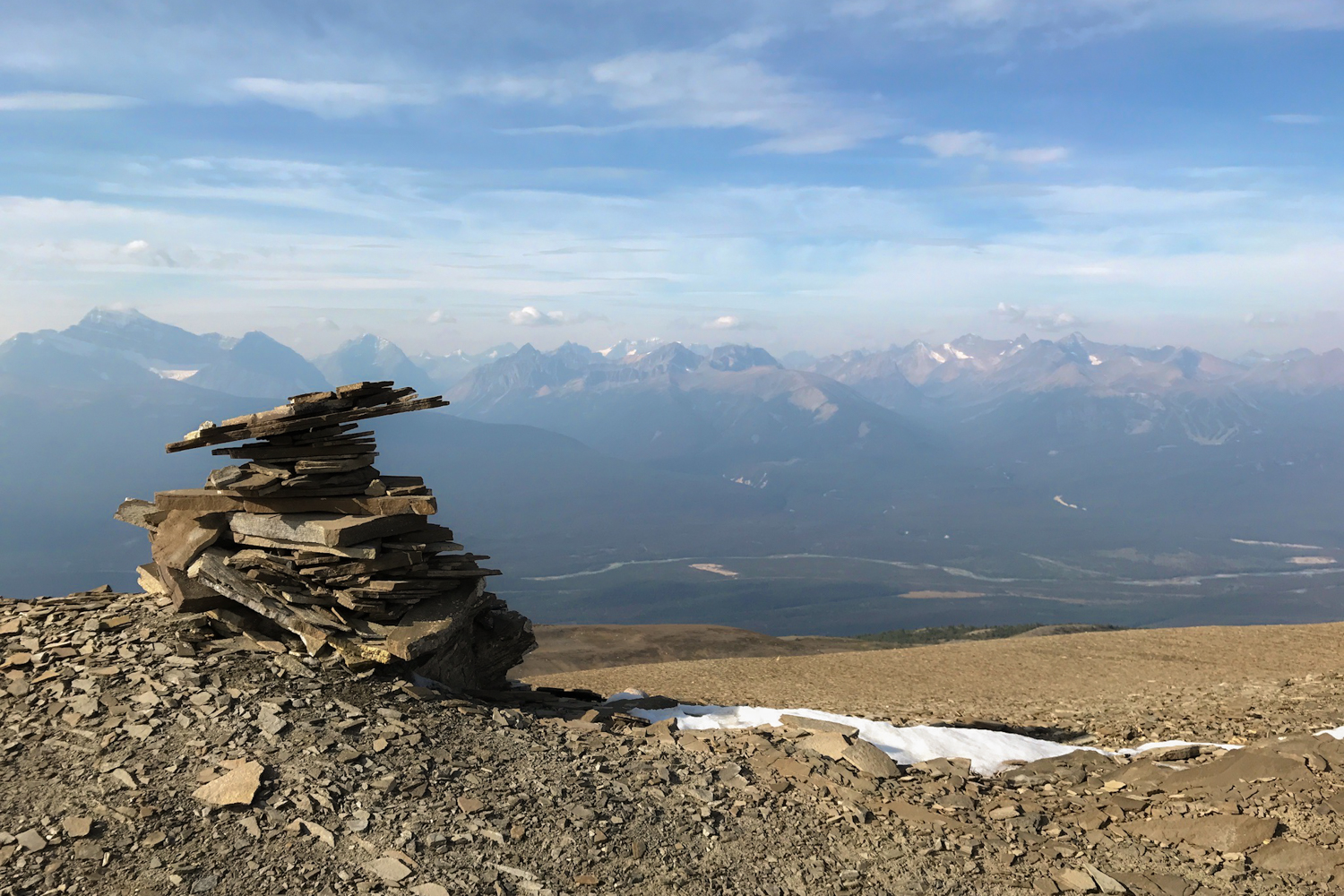 a rock cairn overlooking a mountain range in alberta